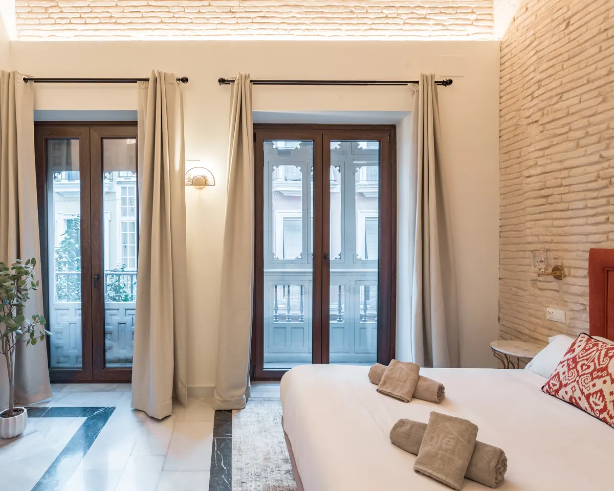 Habitación de hotel con balconeras de madera en fachada histórica