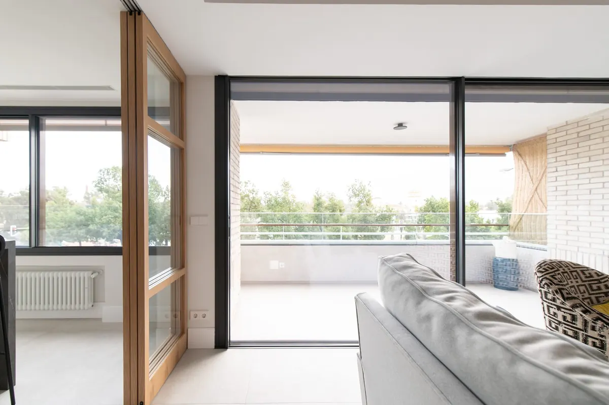 Interior de vivienda con grandes correderas de suelo a techo hacia la terraza, obra OA110