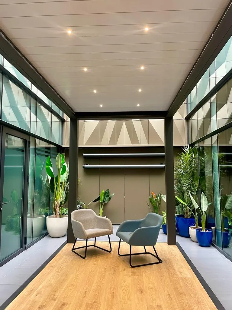 Pérgola bioclimática con lamas, cerramiento de vidrio e iluminación LED