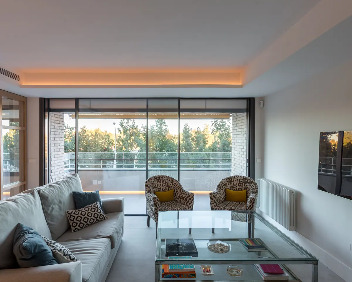 Salón con correderas de aluminio de suelo a techo abiertas a la terraza