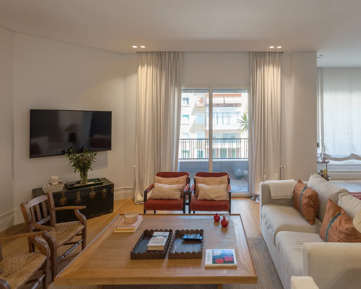 Salón luminoso con balconeras de aluminio blanco hacia la terraza
